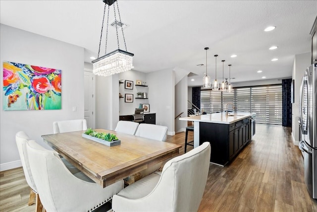 dining room featuring sink, a chandelier, and hardwood / wood-style floors