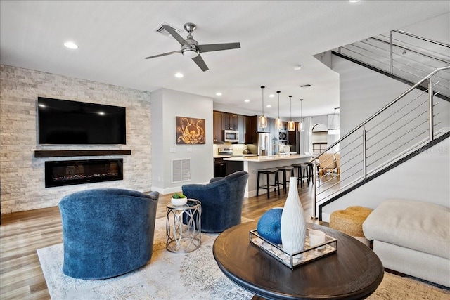 living room featuring ceiling fan and light hardwood / wood-style flooring