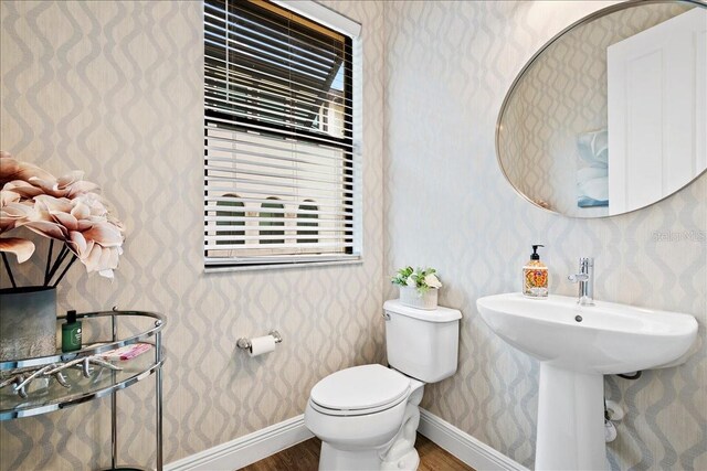 619 Windward Cir S, Boynton Beach, FL 33435 - bathroom with wood finished floors, wallpapered walls, toilet, and baseboards