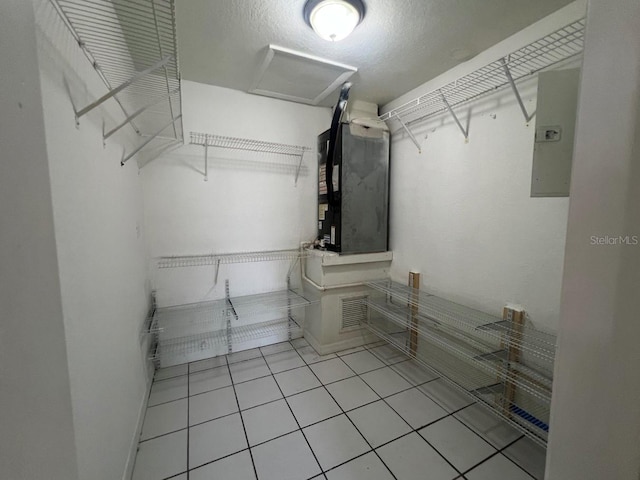 walk in closet featuring heating unit, electric panel, and light tile patterned floors