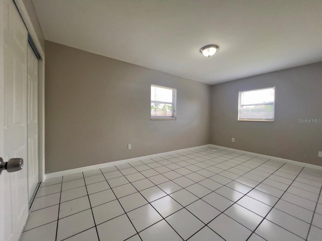 spare room with a healthy amount of sunlight and light tile patterned floors