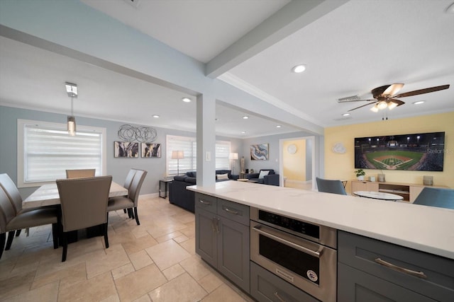 kitchen with gray cabinetry, stainless steel oven, ceiling fan, decorative light fixtures, and ornamental molding