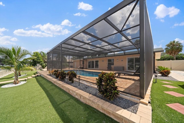 view of pool with glass enclosure, a patio, and a lawn