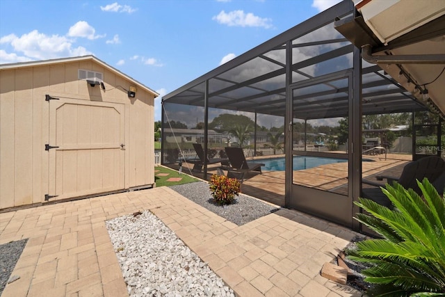 view of patio featuring glass enclosure and a shed