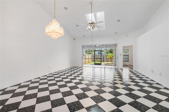 unfurnished room with ceiling fan with notable chandelier and high vaulted ceiling