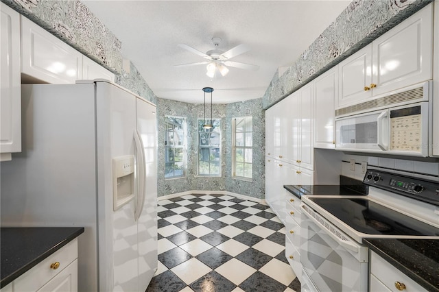 kitchen with white cabinets, pendant lighting, white appliances, and ceiling fan