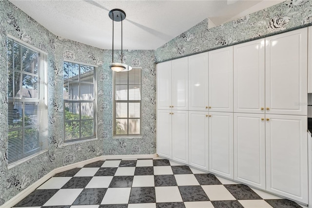 unfurnished dining area featuring a textured ceiling