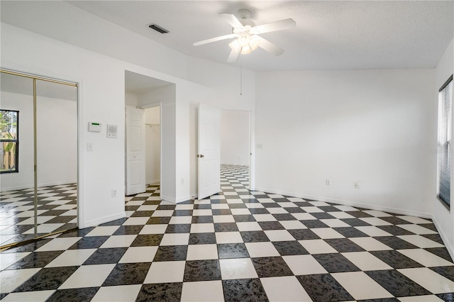 unfurnished room with ceiling fan and a textured ceiling