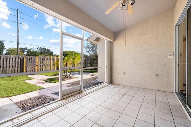 unfurnished sunroom with ceiling fan