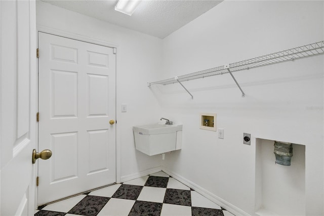 washroom with electric dryer hookup, hookup for a washing machine, and a textured ceiling