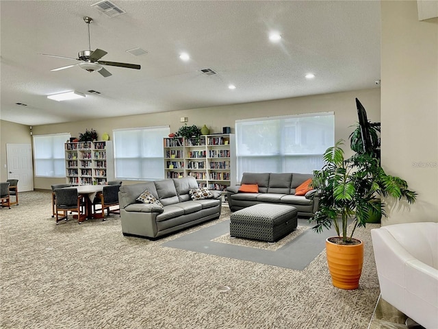 carpeted living room with a textured ceiling, plenty of natural light, and ceiling fan