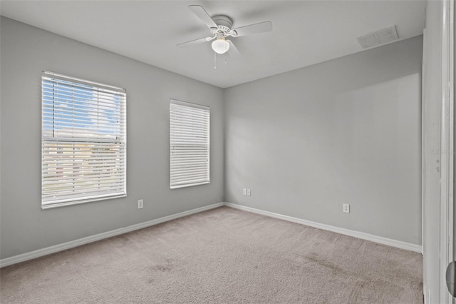 carpeted spare room with ceiling fan