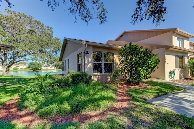 view of front of house with a water view and a front lawn