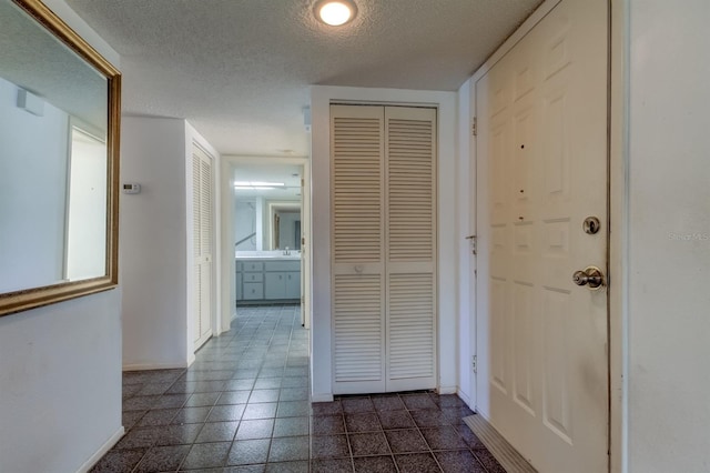 hall featuring a textured ceiling