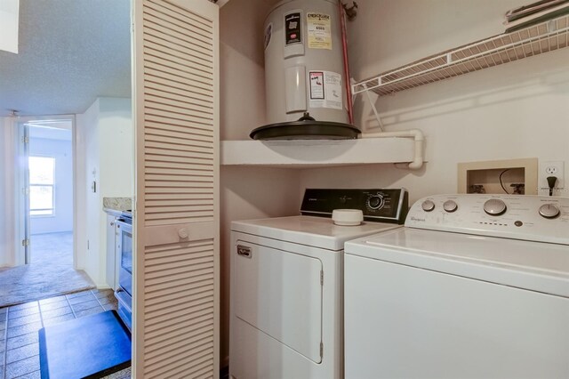 washroom featuring tile patterned floors, washing machine and dryer, and electric water heater