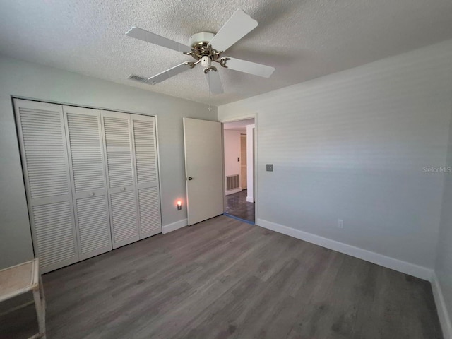 unfurnished bedroom featuring hardwood / wood-style flooring, ceiling fan, a textured ceiling, and a closet