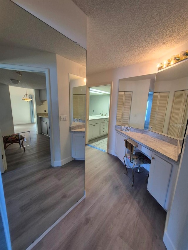 bathroom featuring vanity, wood-type flooring, and a textured ceiling