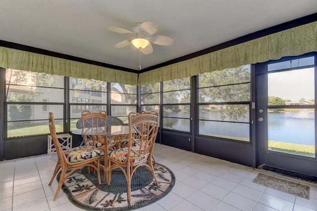 sunroom / solarium featuring ceiling fan and a water view