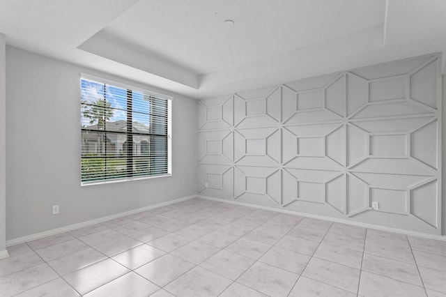 tiled empty room with a tray ceiling