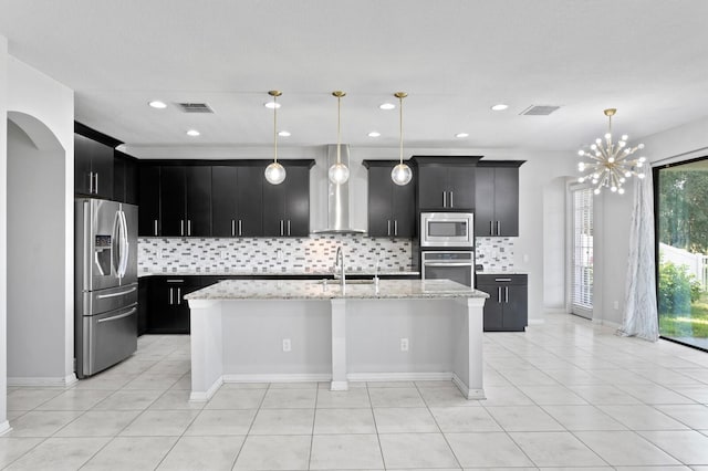 kitchen with visible vents, appliances with stainless steel finishes, arched walkways, a sink, and dark cabinets