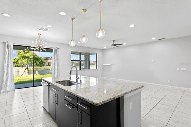 kitchen with sink, an island with sink, decorative light fixtures, and ceiling fan with notable chandelier