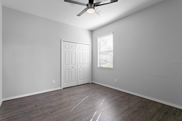 unfurnished bedroom with baseboards, ceiling fan, wood finished floors, and a closet
