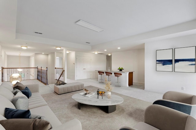 living area featuring light colored carpet and visible vents