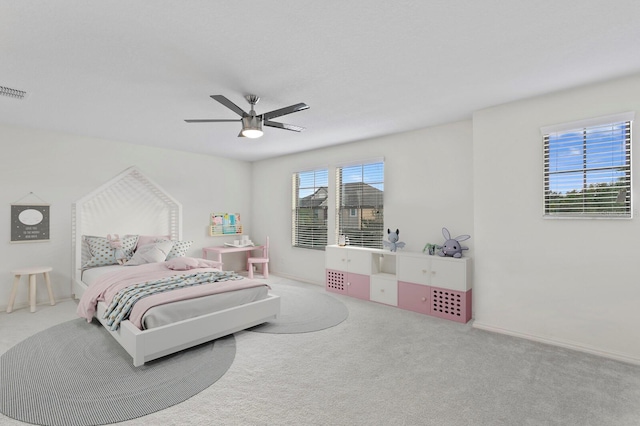 carpeted bedroom featuring a ceiling fan and visible vents