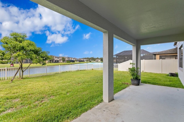 view of yard with a fenced backyard, a water view, and a patio area
