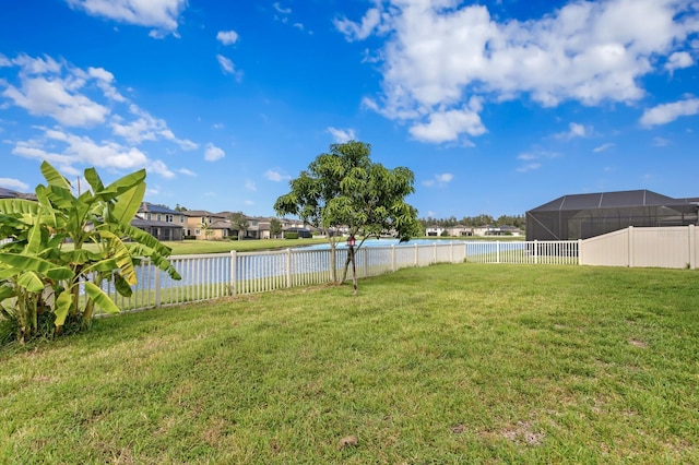 view of yard with a water view and fence