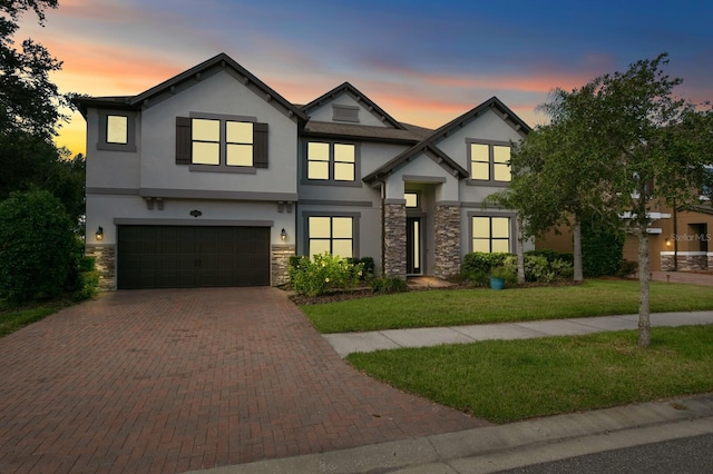 view of front of property featuring decorative driveway, stucco siding, and stone siding
