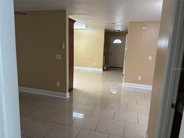 tiled spare room featuring a textured ceiling