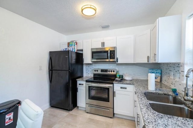 kitchen featuring white cabinets, appliances with stainless steel finishes, tasteful backsplash, and sink