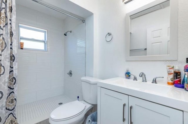 bathroom with walk in shower, vanity, and toilet