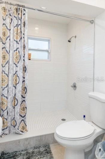 bathroom with walk in shower and toilet