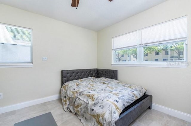 bedroom with ceiling fan and multiple windows