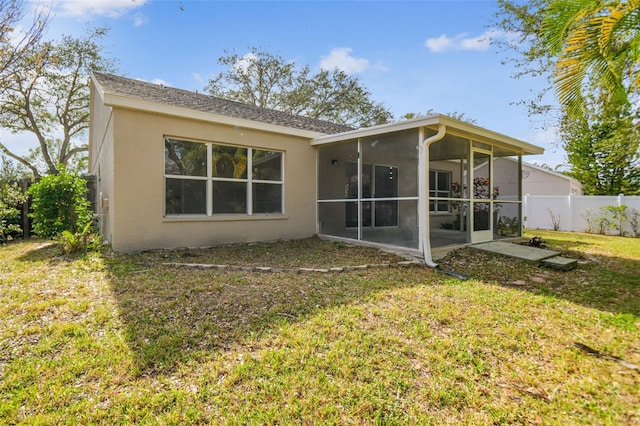 rear view of property with a sunroom and a lawn