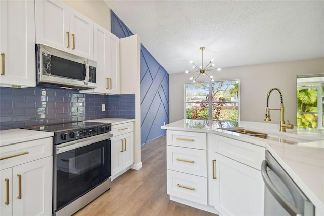 kitchen with white cabinets, sink, light wood-type flooring, and stainless steel appliances