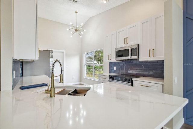 kitchen with sink, light stone counters, a textured ceiling, white cabinets, and appliances with stainless steel finishes