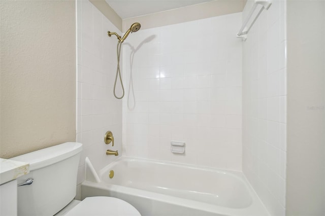 bathroom with tiled shower / bath combo and toilet