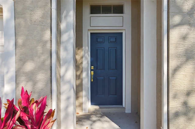 property entrance with stucco siding