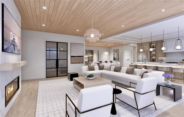 living room with a tray ceiling, light hardwood / wood-style floors, wooden ceiling, and sink