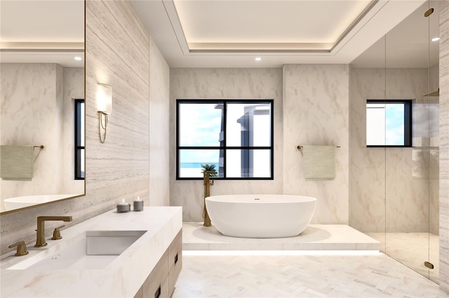 bathroom with vanity, separate shower and tub, and a raised ceiling