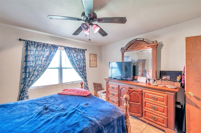 tiled bedroom featuring ceiling fan and a textured ceiling