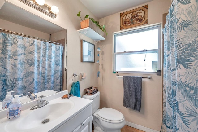 bathroom featuring a wealth of natural light, vanity, and toilet