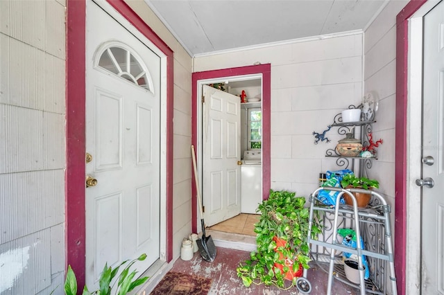 entrance to property featuring a porch and washer / dryer