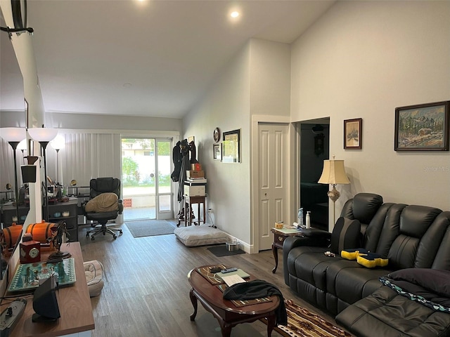 living room with light wood-type flooring and high vaulted ceiling