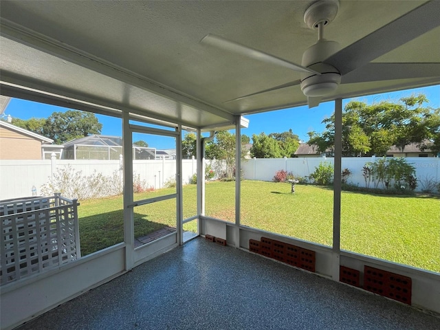 unfurnished sunroom featuring ceiling fan