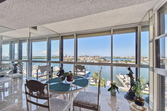 sunroom with a water view and a wealth of natural light