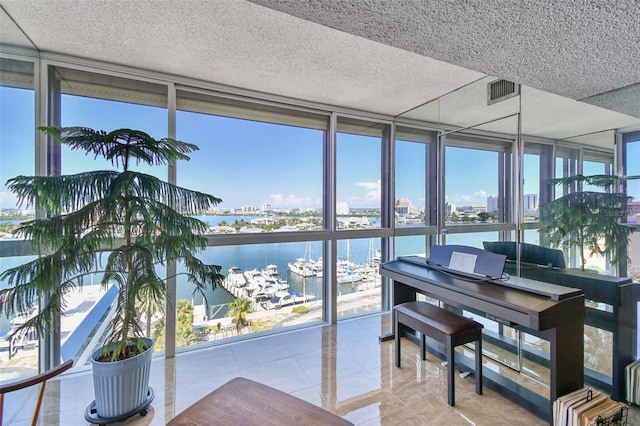 miscellaneous room with a textured ceiling, light tile patterned flooring, floor to ceiling windows, and a water view